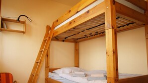 Een stapelbed met houten frame en een plank erboven.