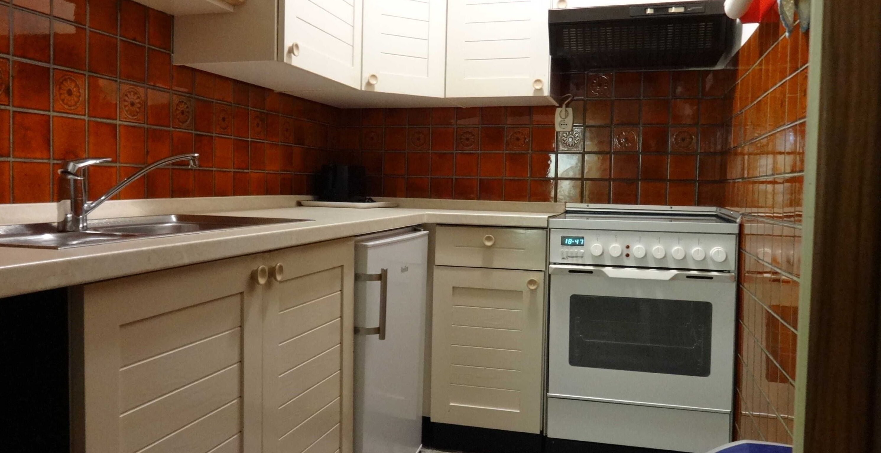 Kjøleskap, ovn og høy barnestol