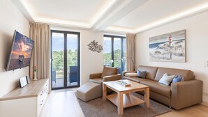 A modern living room with a sofa, coffee table, and a TV mounted on the wall.