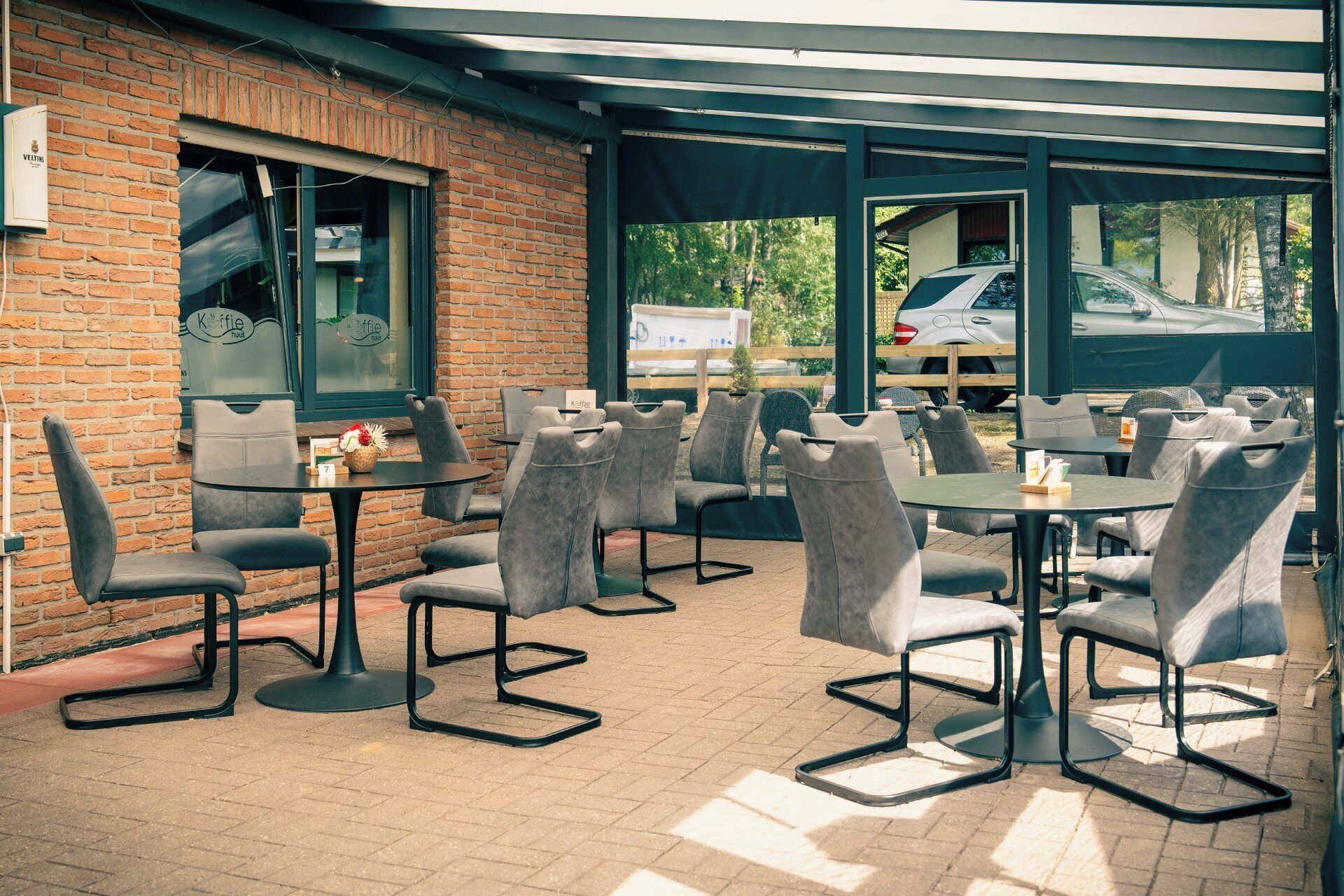 An outdoor seating area with brick walls, tables, and chairs.