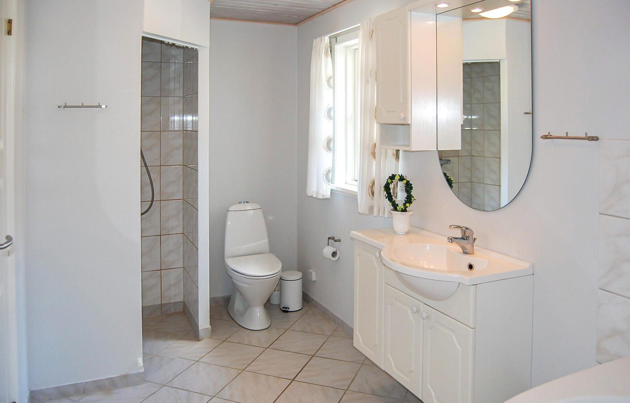Une salle de bain comprenant des toilettes, un lavabo et un espace douche.