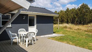 Una casa pequeña con un patio que tiene una mesa y sillas.