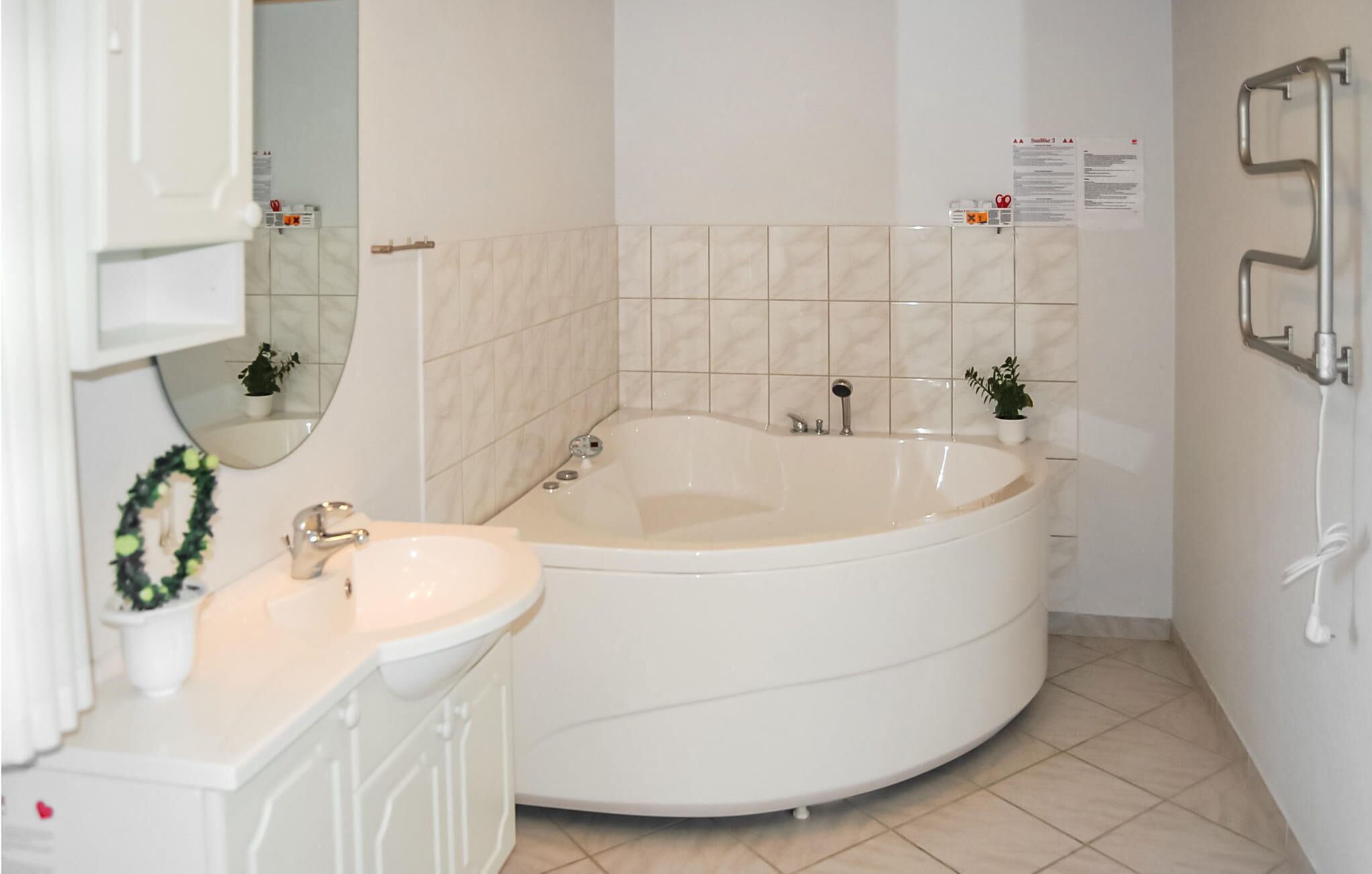 A bathroom with a freestanding bathtub, a sink, and a mirror.