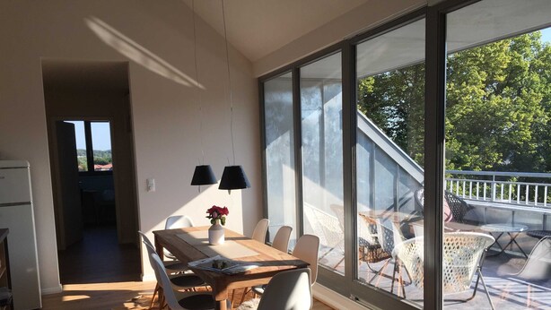 Un comedor moderno con una mesa grande, sillas y vistas al exterior.