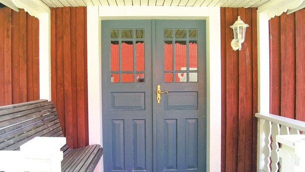 A blue door with a window, a bench, and a white lantern on the porch. - Lovely home in Annerstad with sauna (Annerstad)