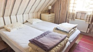 A bedroom with two beds, a nightstand, a lamp, and a window with curtains. - Lovely home in Annerstad with sauna (Annerstad)
