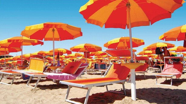 A beach with numerous sun umbrellas and lounge chairs. - Nice home in Caldana -GR- (Caldana -GR-)