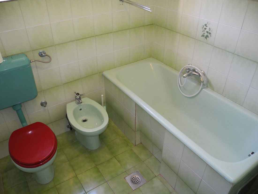 Pieni kylpyhuone, jossa on wc, bidee ja kylpyamme.