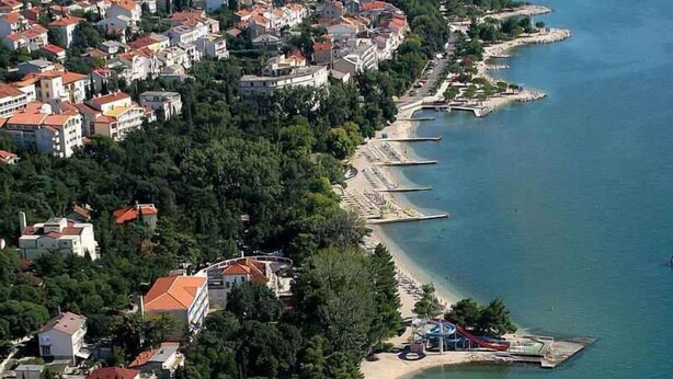An aerial view of a coastal town with a beach, buildings, and boats. - Holiday apartment with terrace (Crikvenica)