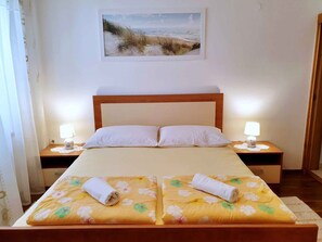 Cozy retreat with a single bed, wooden nightstands, and a framed beach scene.