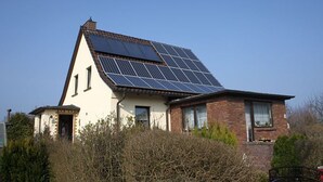 Una casa con techo inclinado y paneles solares.