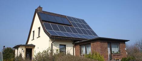 Una casa con techo inclinado y paneles solares.