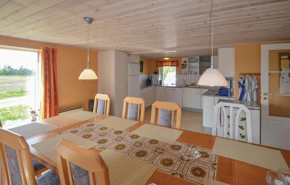 Interior acollidor d'una cabana amb menjador, cuina i vistes a l'exterior.