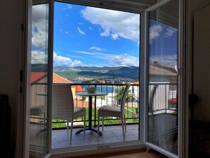 Enjoy breathtaking views of the coastal town and surrounding mountains from this balcony.