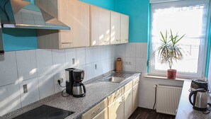 Une cuisine équipée d’une cuisinière intégrée, d’une machine à café et d’un grille-pain.