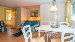 A cozy living room with a sofa, chairs, a dining table, and a mirror on the wall. - App.9 - Priel Hüs, Germany (List)