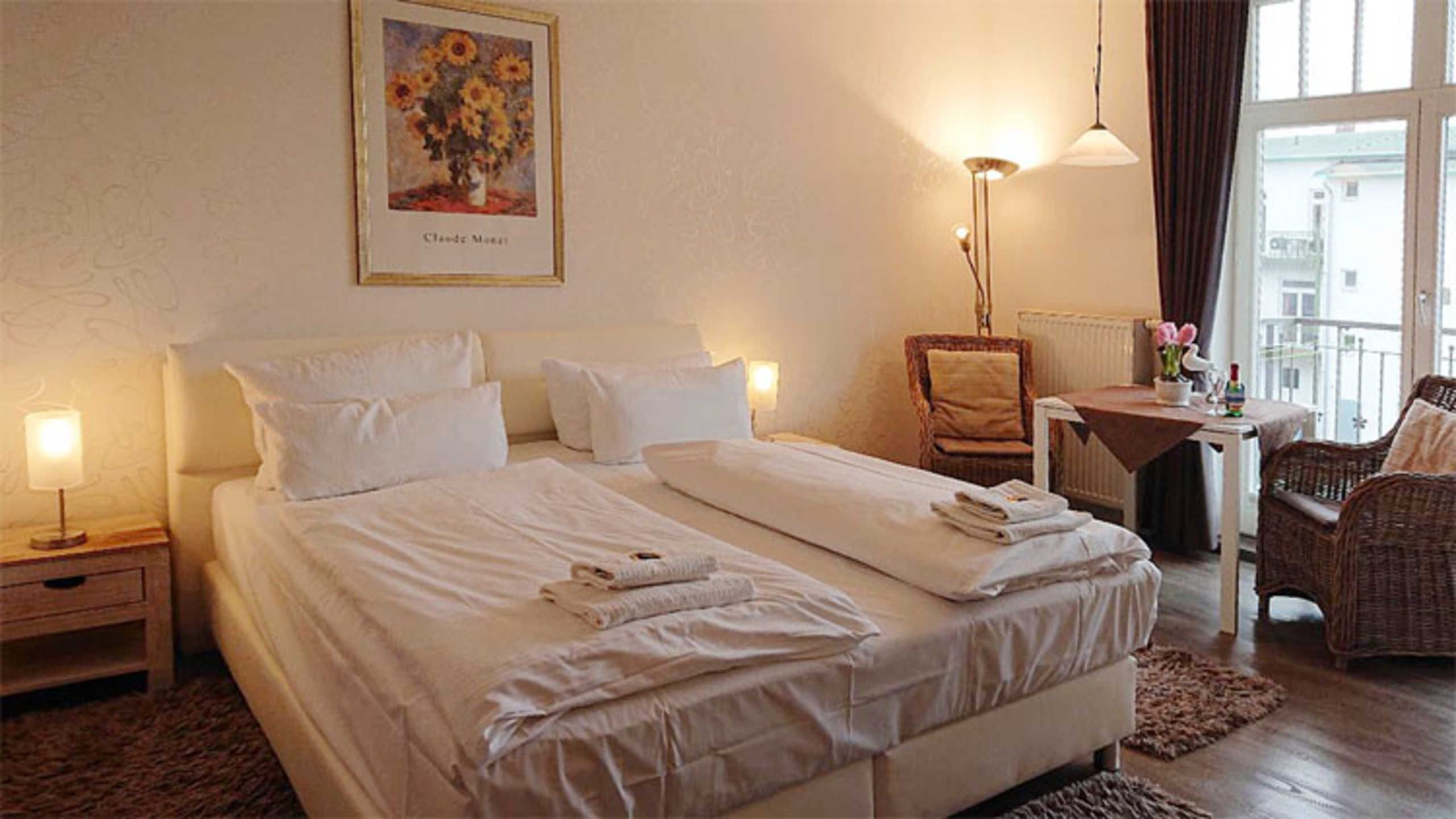 Una habitación de hotel con cama, una silla, una mesa y una ventana.