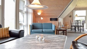 A cozy living room with a blue sofa, a marble coffee table, and a wooden ceiling. - Gorgeous home in Ringkøbing with sauna (Ringkøbing)