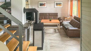 A modern living room with a fireplace, a sofa, a coffee table, and a staircase.