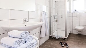 Une salle de bain moderne avec un lavabo, un miroir et une douche à parois en verre.