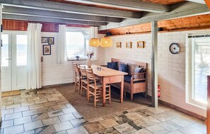 A cozy kitchen with a wooden table and chairs, a bench, and a window with curtains. - Awesome home in Haderslev with WiFi (Haderslev)