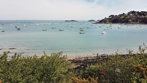 A coastal scene with boats on calm waters, rocky terrain, and dense vegetation. - 2 bedroom gorgeous home in La Fresnais (La Fresnais)