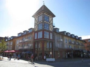 A multi-story building with a prominent corner tower, balconies, and a ground-level entrance. - (110) 3-room apartment - lake view - apartment complex Baltic Sea (Kühlungsborn)