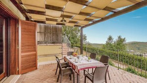 A covered outdoor patio with a table set for dining, a staircase leading to an upper level, and a view of the countryside. - Gorgeous home in Sperlonga -LT- (Sperlonga -LT-)