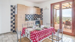 A compact kitchen with modern appliances and a dining area with a red polka dot tablecloth. - Gorgeous home in Sperlonga -LT- (Sperlonga -LT-)