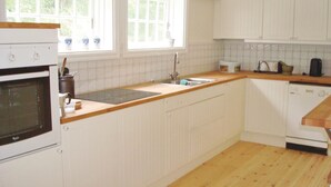 A kitchen with white cabinetry, a wooden countertop, a sink, and a dishwasher. - 2 bedroom stunning home in Strängnäs (Strängnäs)