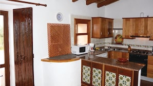 A kitchen with wooden cabinets, a microwave, a sink, and a stove.