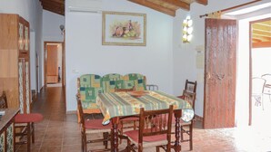 A dining area with a table set for four, a wooden bench, and a painting on the wall.