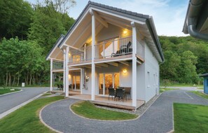 A two-story house with a balcony, a covered porch, and a driveway. - Lovely home in Thale with sauna (Thale)
