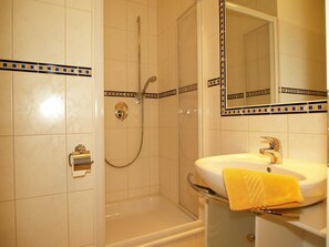 Un baño con bañera, ducha y lavamanos con una toalla.
