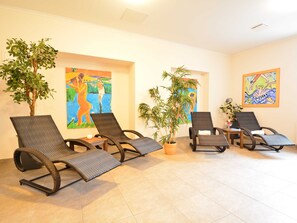 A room with four wicker lounge chairs, a potted plant, and two paintings on the walls. - Residence Starfish Whg S-10 .. - See-10 (Kühlungsborn)