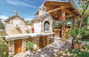 A stone building with a stone chimney, a wooden pergola, and a stone bench. - Gorgeous apartment in Modrusani (Modrusani)