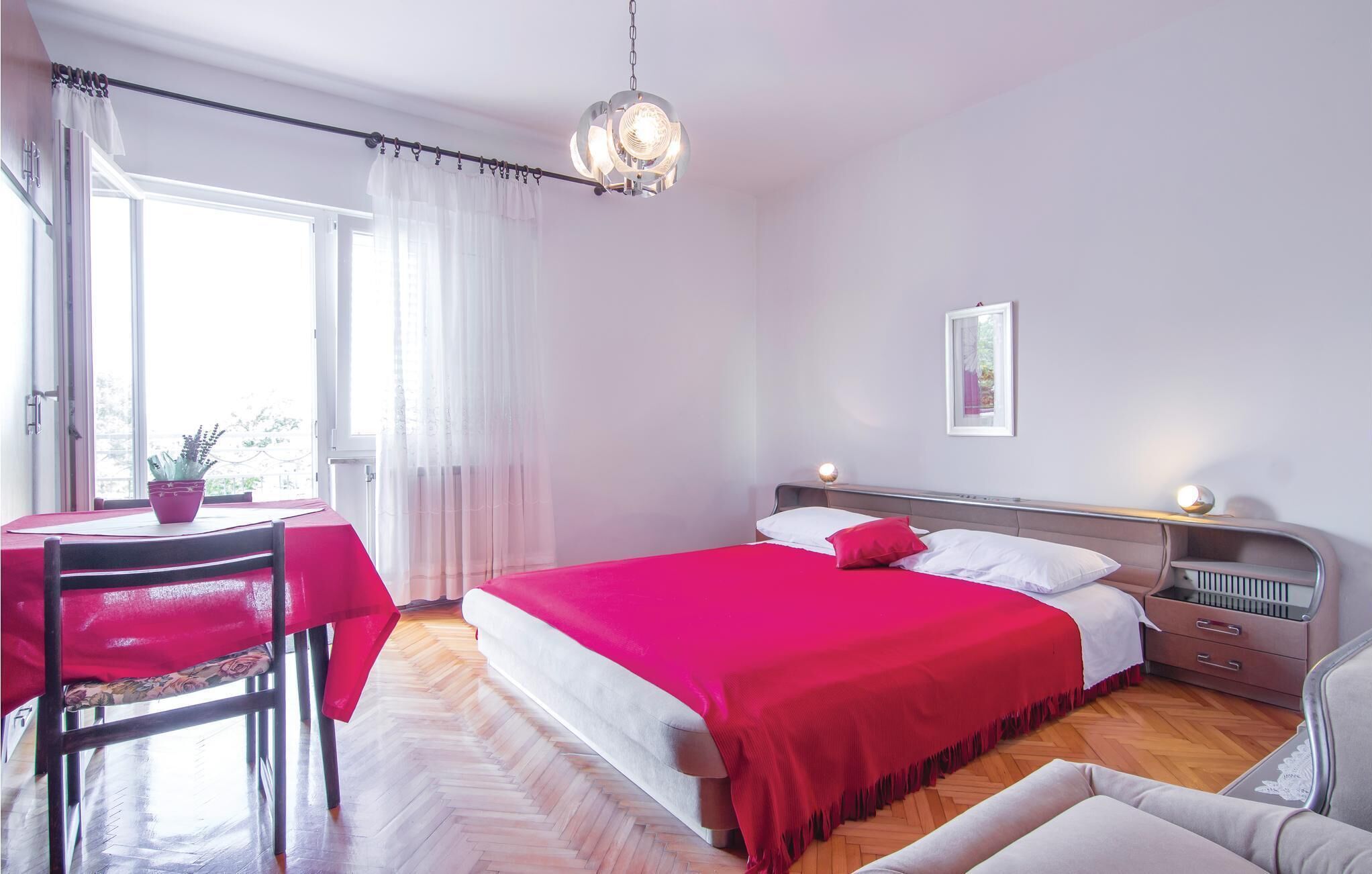 Een slaapkamer met een bed, nachtkastjes, een bureau en een stoel.