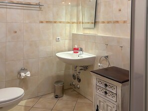 A bathroom with a toilet, sink, and mirror.