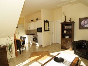 A spacious living area with a dining table, a sofa, and a kitchen in the background. - Metropol Whg. ME-08. - Metropol Whg. 08 (Kühlungsborn)