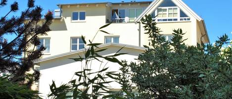 Un edificio de varios pisos con techo plano, ventanas grandes y un balcón.