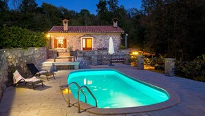 A stone house with a swimming pool, outdoor seating, and a stone wall. - Gorgeous home in Poljane with sauna (Poljane)