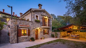A stone house with a balcony, a fireplace, and a patio area. - Gorgeous home in Poljane with sauna (Poljane)