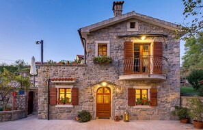 Experience a traditional architectural style with a welcoming entrance and serene garden surroundings.