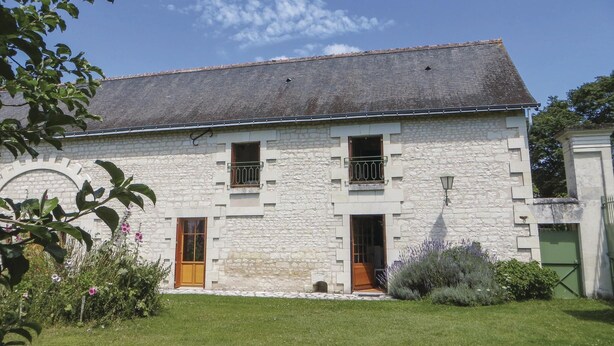 A two-story stone building with a sloped roof, two visible balconies, and a small front garden. - 3 bedroom nice home in Ligre (Ligre)