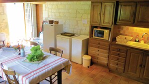 A compact kitchen with a refrigerator, microwave, and wooden cabinets. - 3 bedroom nice home in Ligre (Ligre)