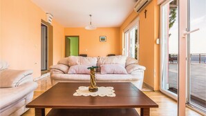 A living room with a beige sofa, a wooden coffee table, and a large window. - 4 bedroom beautiful home in Brela (Brela)
