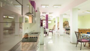 A modern kitchen with a built-in stove, a dining area with a table and chairs, and a foosball table. - 4 bedroom beautiful home in Brela (Brela)