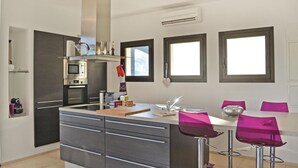 Een moderne keuken met een centraal eiland, roestvrijstalen apparatuur en een raam met uitzicht op de stad.