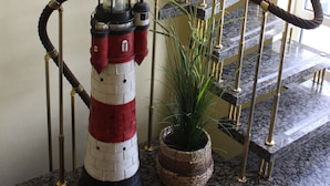 A spiral staircase with a rope barrier, a lighthouse-like structure, and a potted plant. - Apartment 3 Shell - House Birkenallee / Reckleben GM 69705 (Graal-Müritz)