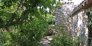 Ein Steingebäude mit einem Gartenweg, der davor führt.
